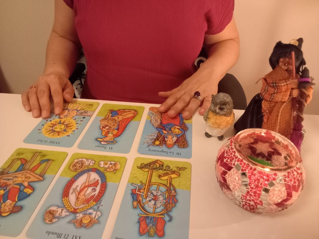 Mesa de consulta de tarot preparada con tres cartas